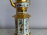 a gold and white tea pot on a marble table