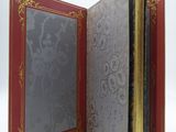 a red and gold book with a picture in it