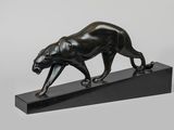 une sculpture en bronze représentant une panthère posée sur un socle noir