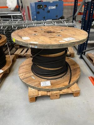 une table en bois sur laquelle est posée une bobine, dans un entrepôt