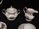 four pieces of porcelain tea set on a black table