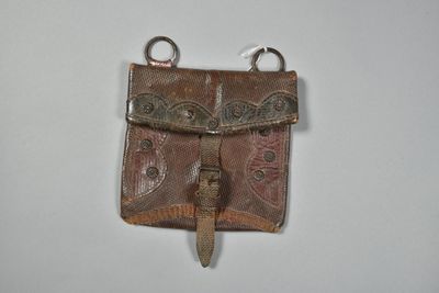 brown leather purse hanging on a wall on a white surface
