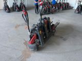 a man standing in a garage with a machine in front of him