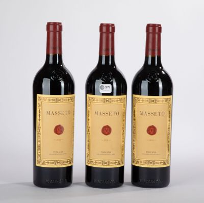 trois bouteilles de vin rouge posées côte à côte sur une table