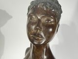 a bronze statue of a woman with her eyes closed