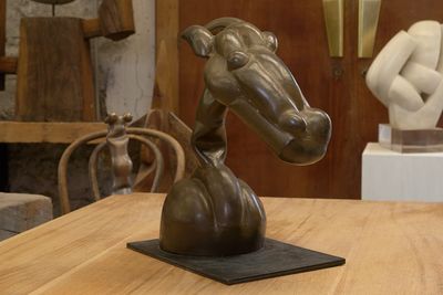 une statue de cheval posée sur une table dans une pièce
