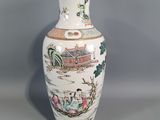 a white vase with a painting on it sitting on a table