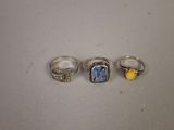 three rings with a blue topaz stone and a yellow topaz stone