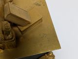 a statue of a man holding a cross on top of a book