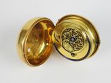 a close up of a gold locke with a blue and white design on it