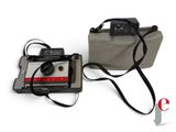 an old camera and a bag on a white surface