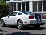 a white mustang parked in front of a building