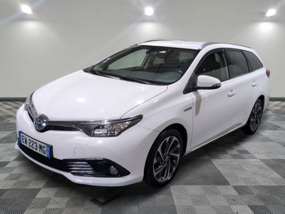 La Toyota Auris blanche est garée sur un sol à damier.