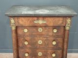 une commode ancienne avec un dessus en marbre et des poignées en laiton