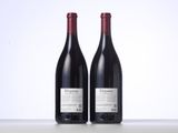 two bottles of red wine sitting next to each other on a table