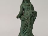 a green statue of a woman sitting on a chair