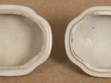 pair of white porcelain bowls on a brown surface