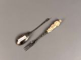 two spoons and a fork sitting on a table