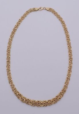 un collier à chaîne dorée avec un motif de nœud sur fond blanc
