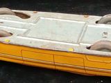 a yellow toy boat that is sitting on a black surface