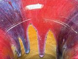 a close up of a red and purple bowl on a table