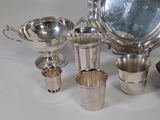 a lot of silver dishes and cups sitting on a table