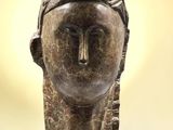 un gros plan sur la sculpture d'une tête de femme posée sur une table