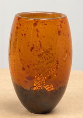a brown vase sitting on top of a wooden table