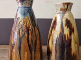 two vases that are sitting on a wooden table