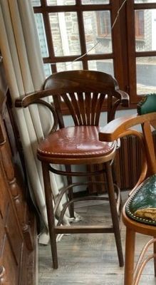 un chat assis sur une chaise devant une fenêtre