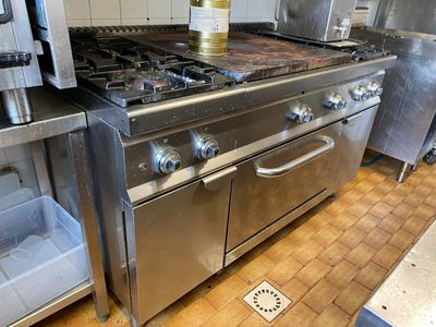 une cuisine équipée d'une cuisinière, d'un four, d'un évier et d'un réfrigérateur