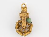 an image of a gold pendant with a green stone in the center