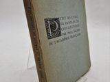 un vieux livre posé sur une table blanche, à côté d'un présentoir en verre