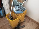 a mop and a bucket on the floor next to a door