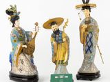 three chinese figurines of women with hats and holding musical instruments