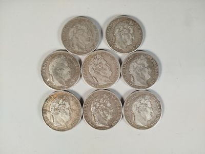 six different british coins sitting on top of each other on a white surface