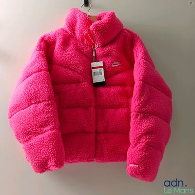 the pink jacket is hanging on a hook on the wall
