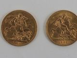 five gold coins are arranged in a row on a white surface