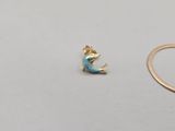 a close up of a ring with a mermaid tail on a table