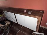 une armoire blanche avec un plateau en bois dans une pièce