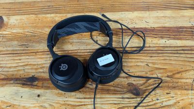 un casque audio noir posé sur une table en bois