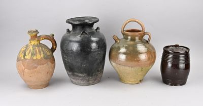 trois vases munis d'anses sont alignés sur un fond blanc