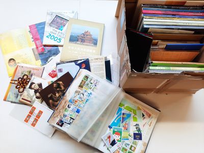 une boîte remplie de livres posée sur une table, à côté d'une pile d'autres livres