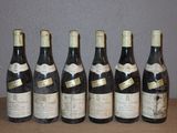 six bouteilles de vin sont alignées sur une table