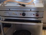 une cuisinière en acier inoxydable équipée d'une grille sur le dessus