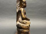 an image of a statue of a woman sitting on top of a wooden block