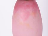 a pink glass lamp with a black base on a table
