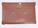 a brown suitcase sitting on top of a white table