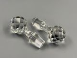 pair of clear glass knobs on a gray surface
