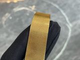 someone is holding a gold wrist watch with a black face